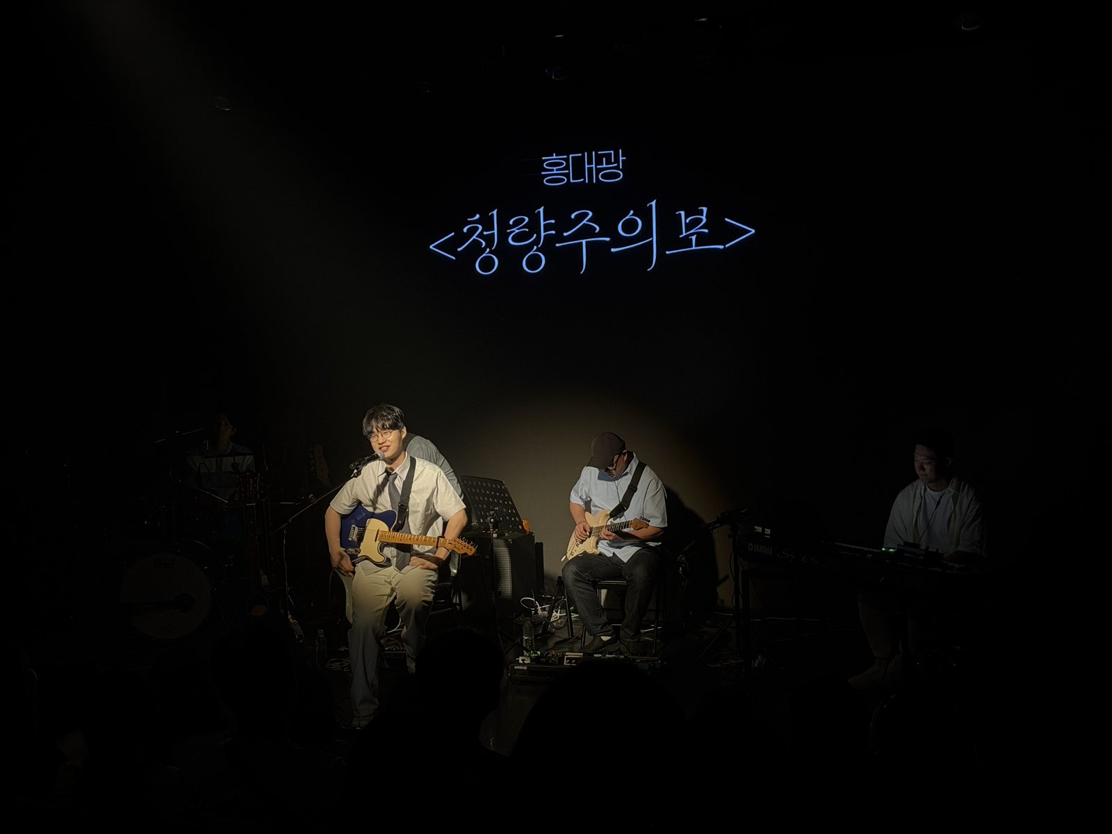 '홍대광 청량주의보' 타이틀이 띄워진 LED 스크린 앞에서 일렉트릭 기타를 치며 노래하는 홍대광과 밴드