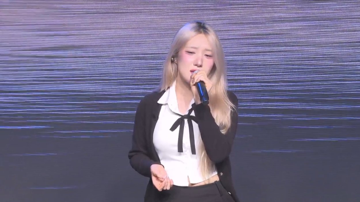 온맘씨어터 프리즘 미니콘서트 — 보랏빛 LED 스크린 앞에서 솔로 곡을 부르는 출연자