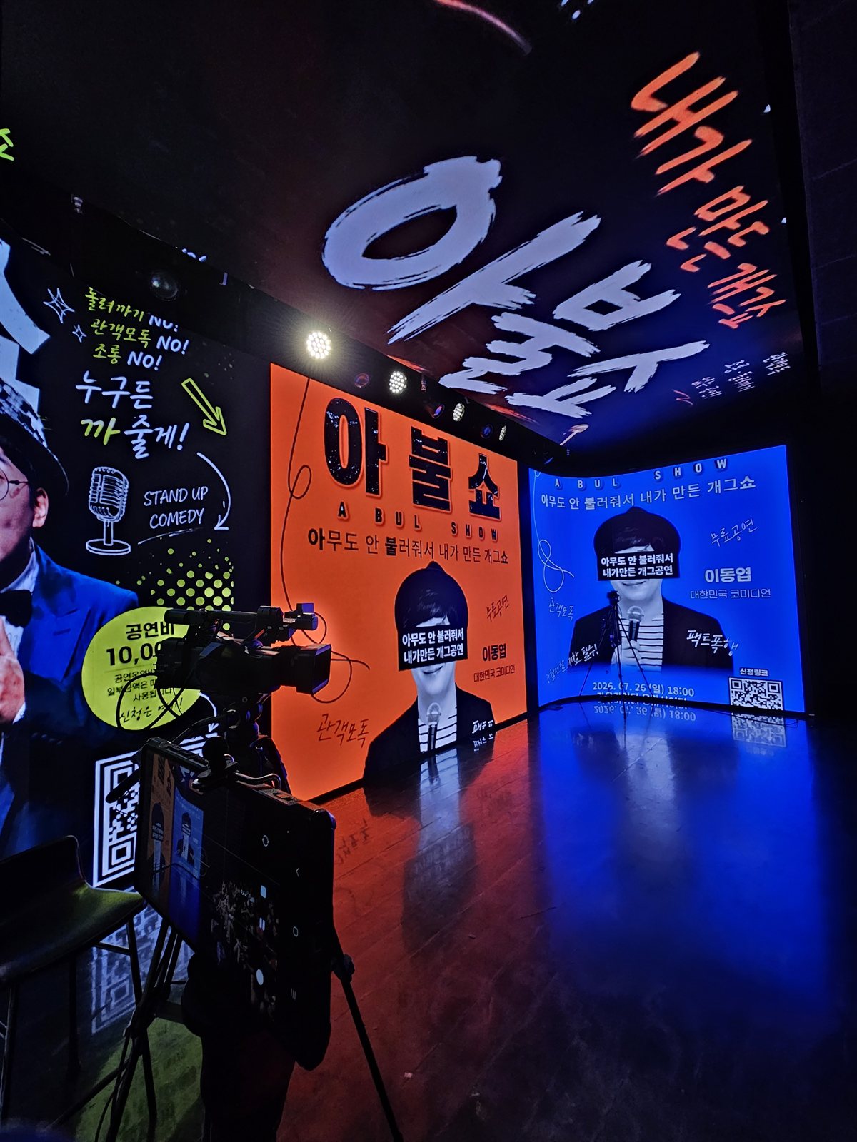 이동엽 아불쇼(ABUL SHOW) 스탠드업 코미디 공연 무대 — 3면 LED 스크린과 천장 스크린 전체에 '아무도 안 불러줘서 내가 만든 개그쇼' 포스터 영상을 띄운 무대와 앞쪽의 촬영용 카메라